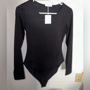 Brand new small black body suit with tags and sleeves